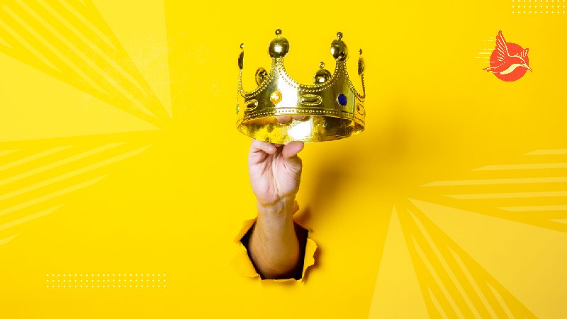 Female hand holding a gold crown